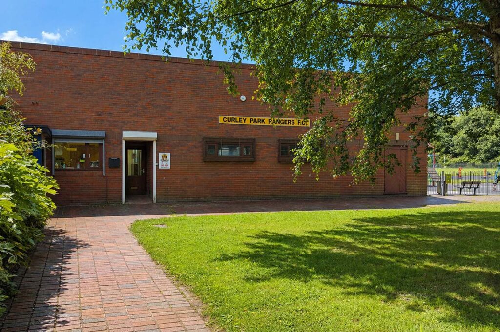 Connaught Pavilion brick building with path and green lawn