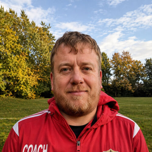 Paul K, Curley Park Rangers FC coach, outdoors in red jacket
